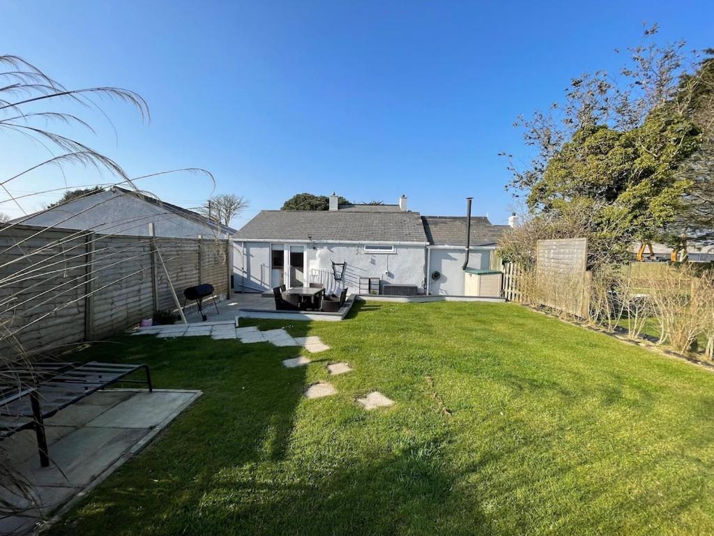 a backyard with a lawn and a house at The Cottage Cox Hill Chacewater in Truro