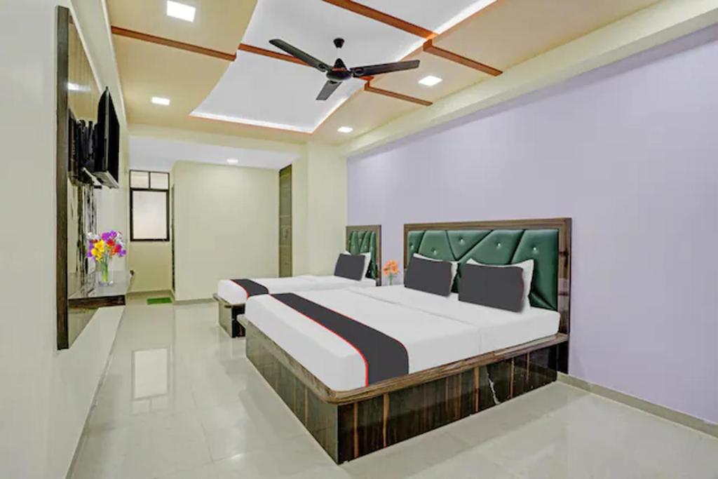 Hotel GGC INN في أحمد آباد: غرفة نوم بسريرين ومروحة سقف