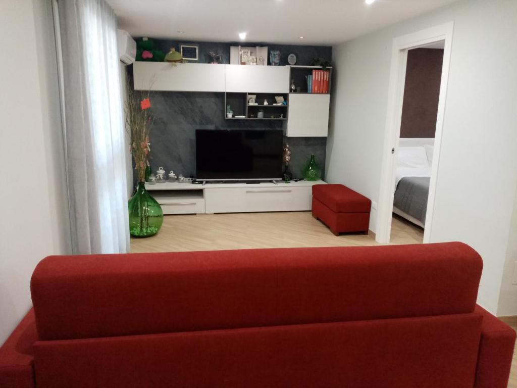 a living room with a red couch and a television at A Casa di Maria 2 in Cavallino di Lecce