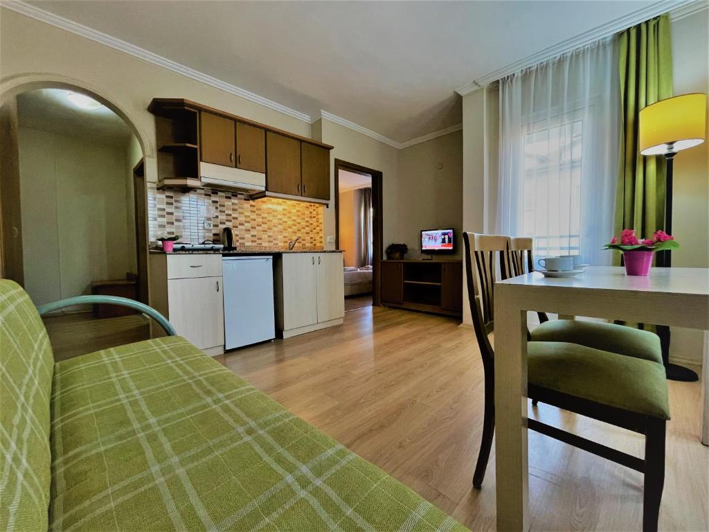 a kitchen and living room with a table and a dining room at Select Suite & Apart Hotel in Alanya