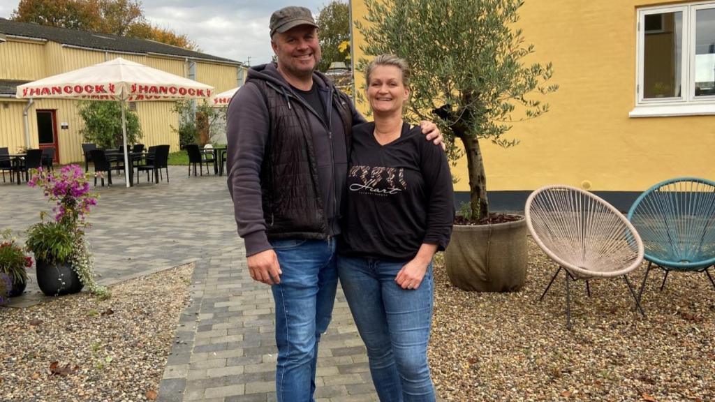 a man and a woman standing in front of a building at Oasen Samsø in Nordby