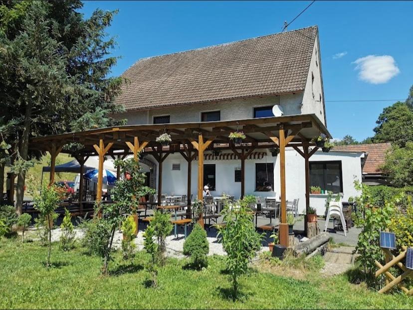 a pavilion with tables and chairs in front of a building at Gasthof zur Sägemühle in Hiltpoltstein