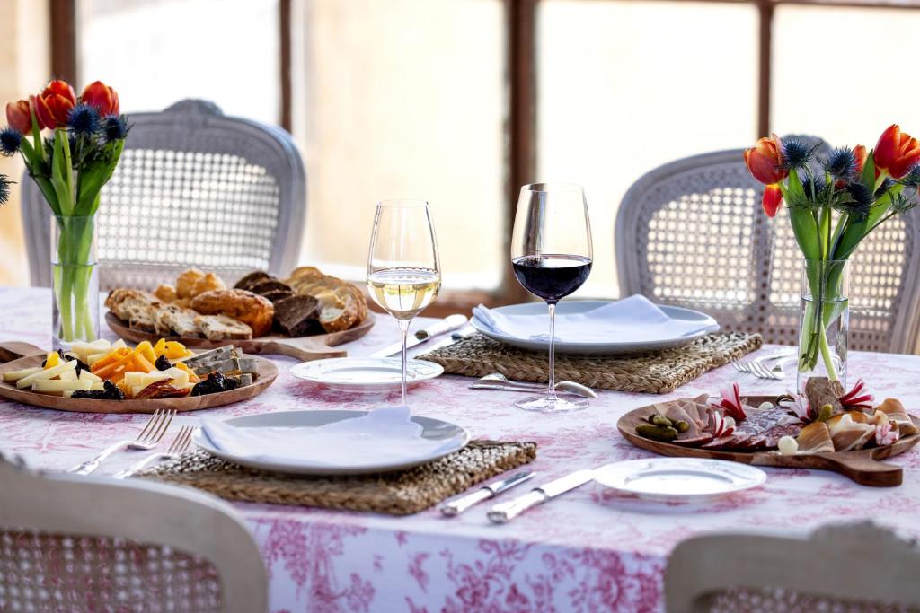 a table with plates and glasses of wine and food at Château du Tertre in Arsac
