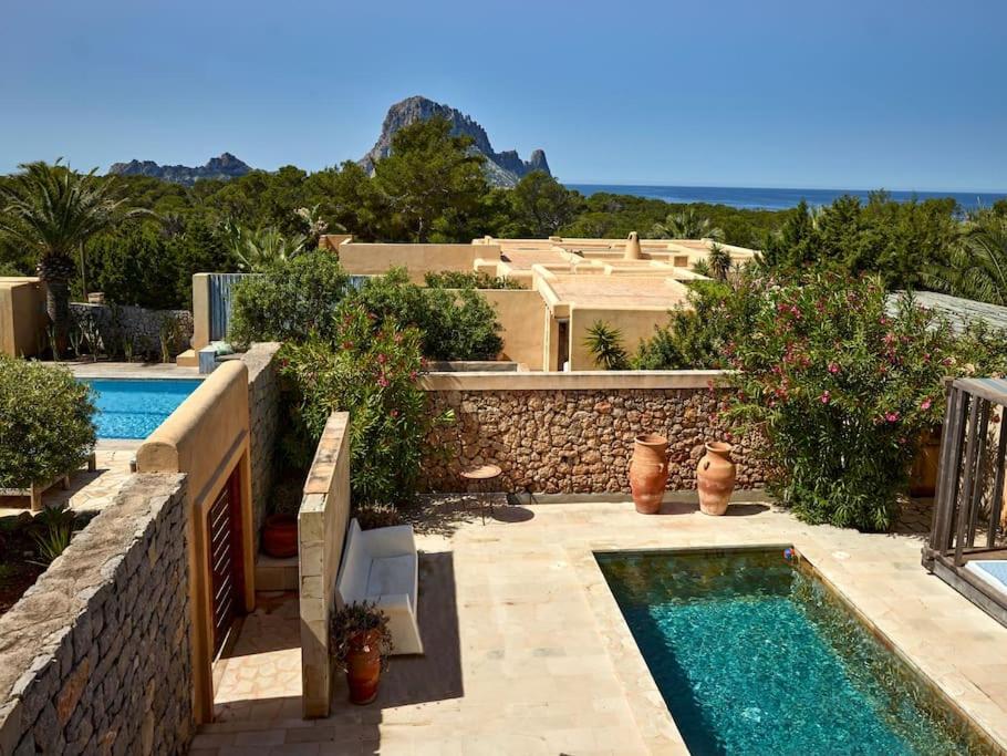 un patio trasero con piscina y una casa en Kasbah 3, en Cala Vadella