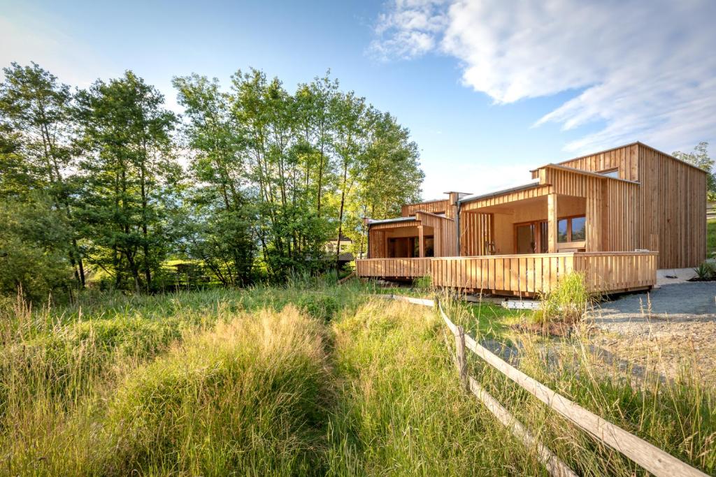 ein Holzhaus auf einem Feld mit Bäumen in der Unterkunft Prefelnig Glamping Lodge Ossiacher See in Ossiach