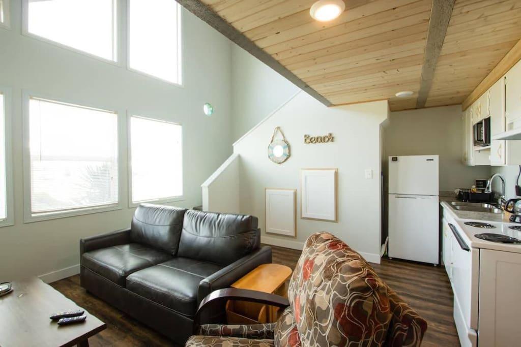 a living room with a leather couch and a kitchen at Tidal House 9 in Ocean Shores