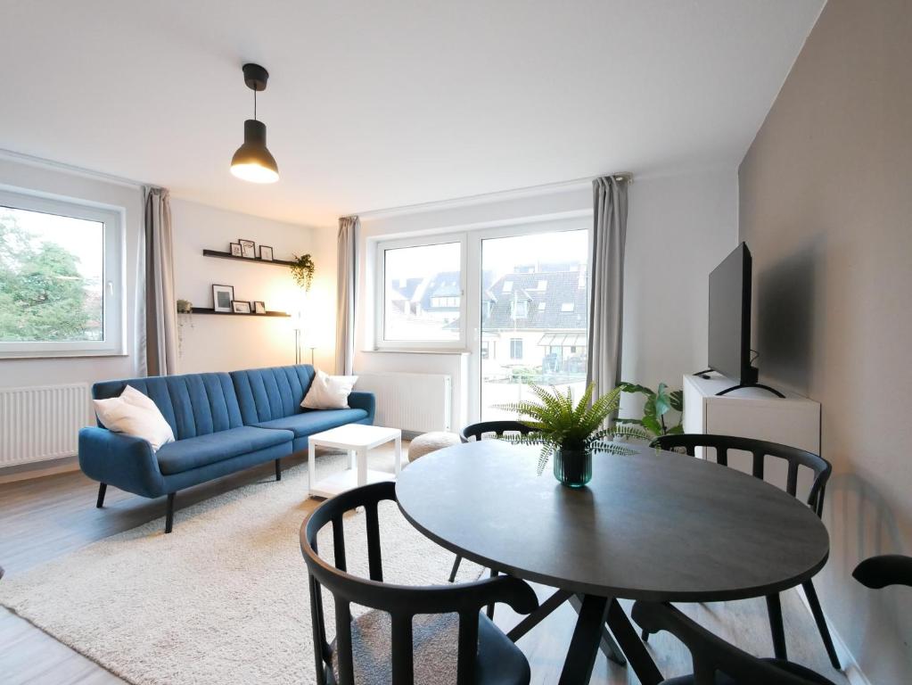 ein Wohnzimmer mit einem Tisch und einem blauen Sofa in der Unterkunft 75 m2, zentral, Küche, Balkon, Parkplatz in Osnabrück