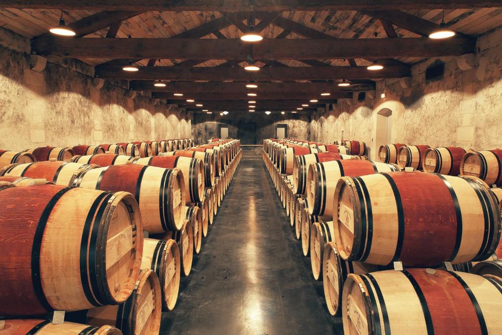a row of wine barrels in a cellar at Château du Tertre in Arsac