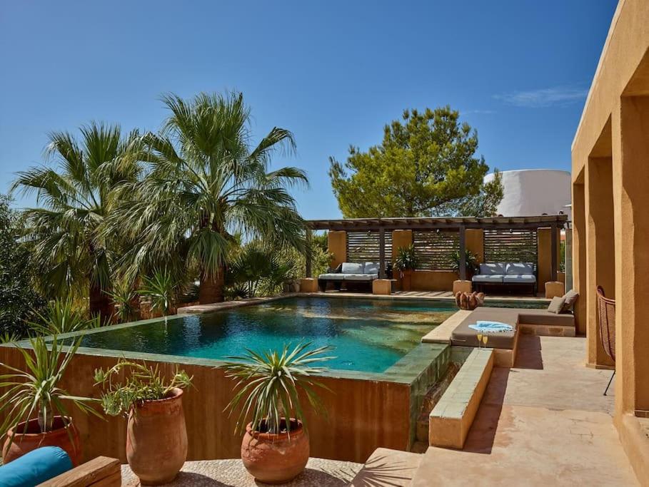 uma piscina com vasos de plantas num pátio em Kasbah 2 em Sant Josep de sa Talaia