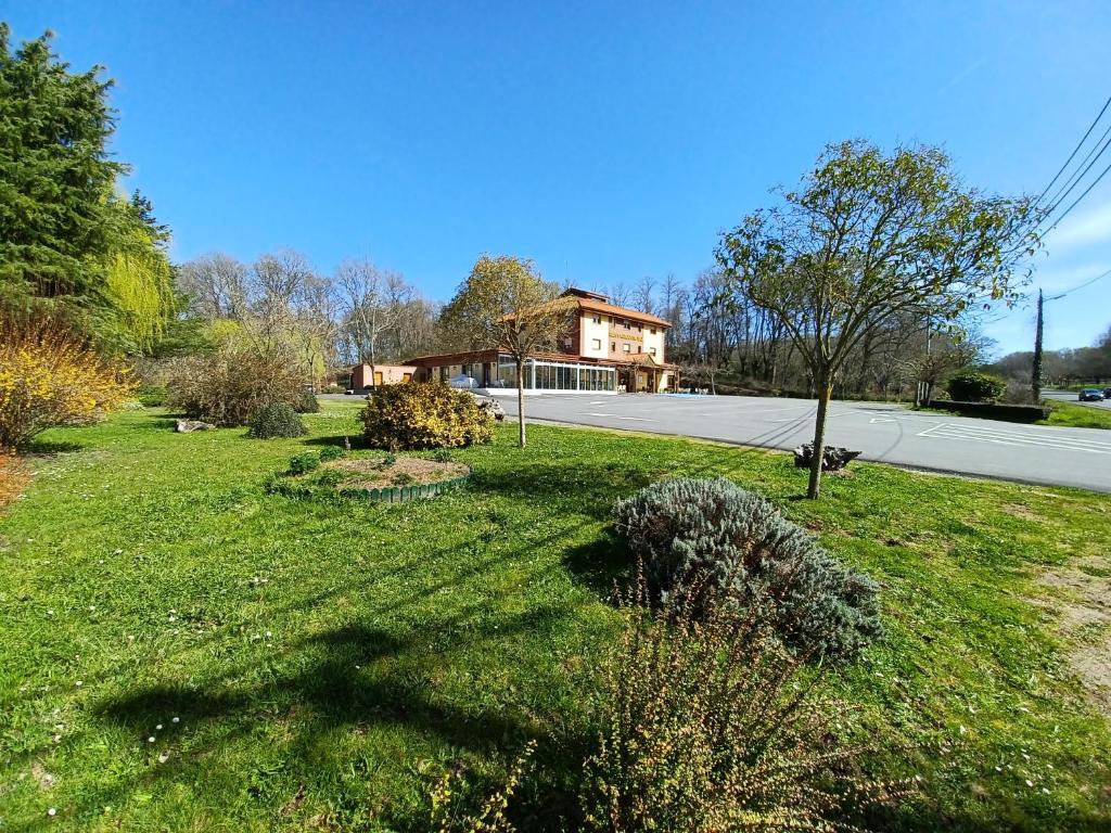 une cour avec une maison sur le côté d'une route dans l'établissement Hotel Restaurante Val, à Antas de Ulla