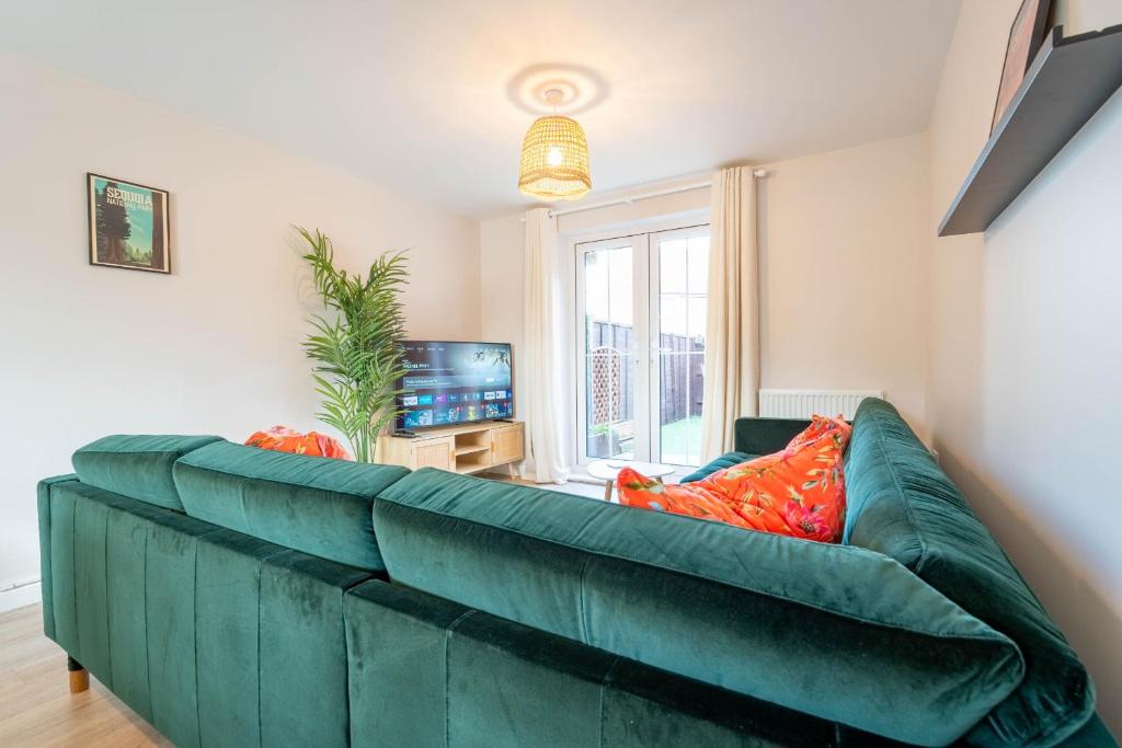 a green couch with orange pillows in a living room at Brookfield in Horley