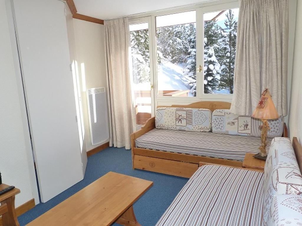 un salon avec un canapé et une fenêtre dans l'établissement Joli 2 pièces cabine rénové, exposition sud, skis aux pieds, Résidence Boedette A, Les Menuires - FR-1-178-182, aux Menuires