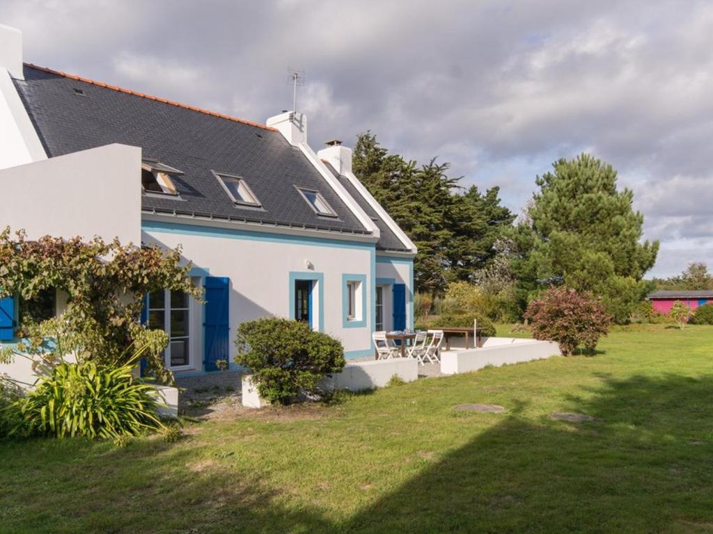 une maison bleue et blanche avec une cour dans l'établissement Grande Maison avec Jardin Près de la Plage - 4 Chambres, WIFI et Cheminée - FR-1-418-5, à Locmaria