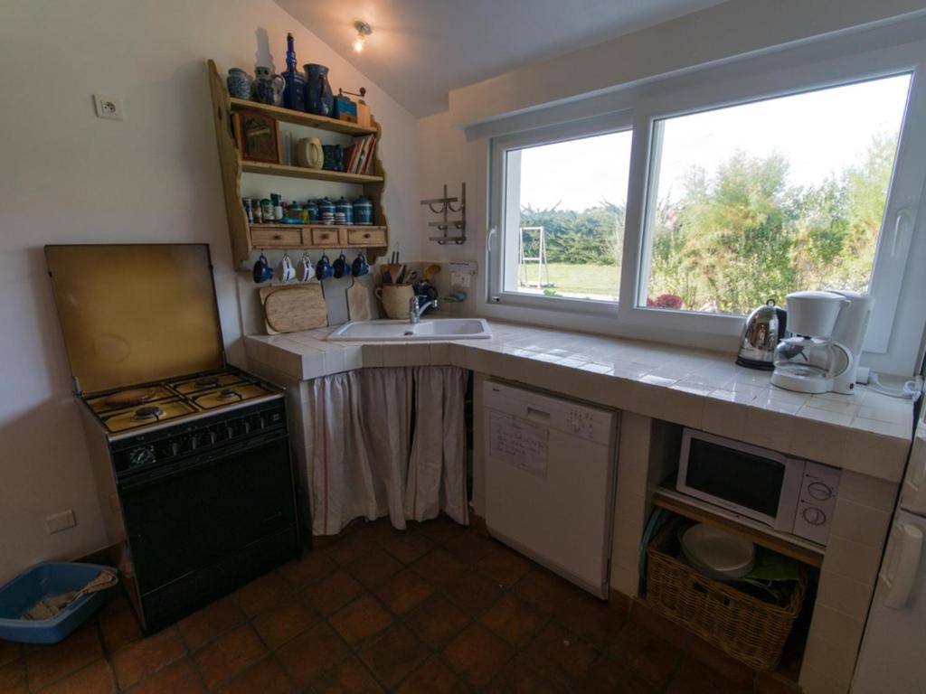 a kitchen with a sink and a stove and a window at Maison Locmaria, 6 pièces, 10 personnes - FR-1-418-5 in Locmaria