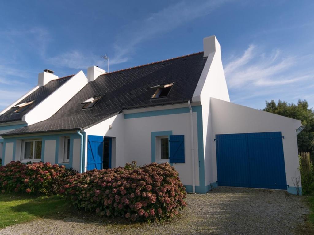 a white and blue house with a blue garage at Maison Locmaria, 6 pièces, 10 personnes - FR-1-418-5 in Locmaria