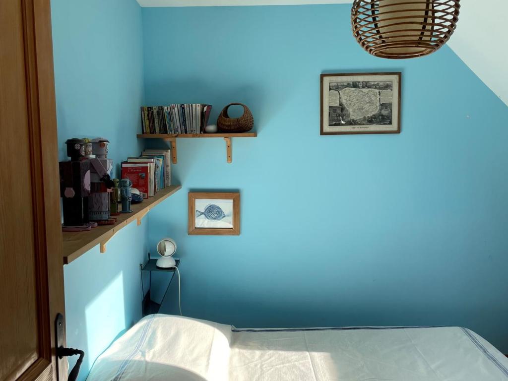 a blue wall with a bed in a room at Maison Locmaria, 6 pièces, 10 personnes - FR-1-418-5 in Locmaria