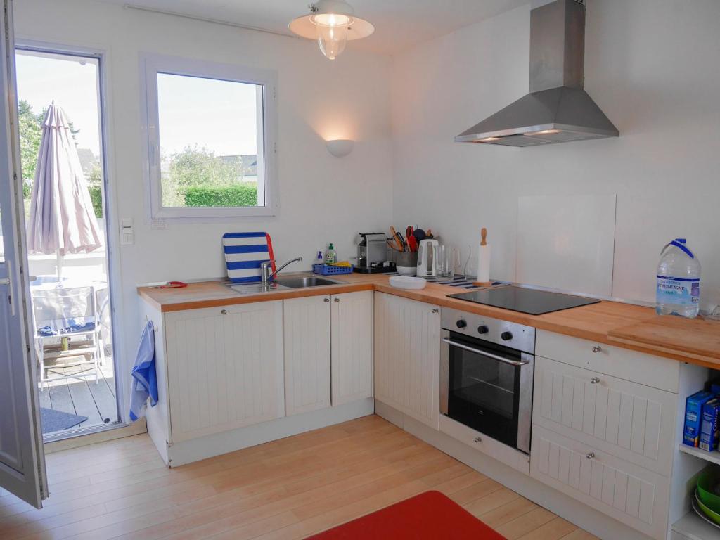 a kitchen with white cabinets and a stove top oven at Maison Le Palais, 5 pièces, 5 personnes - FR-1-418-76 in Le Palais