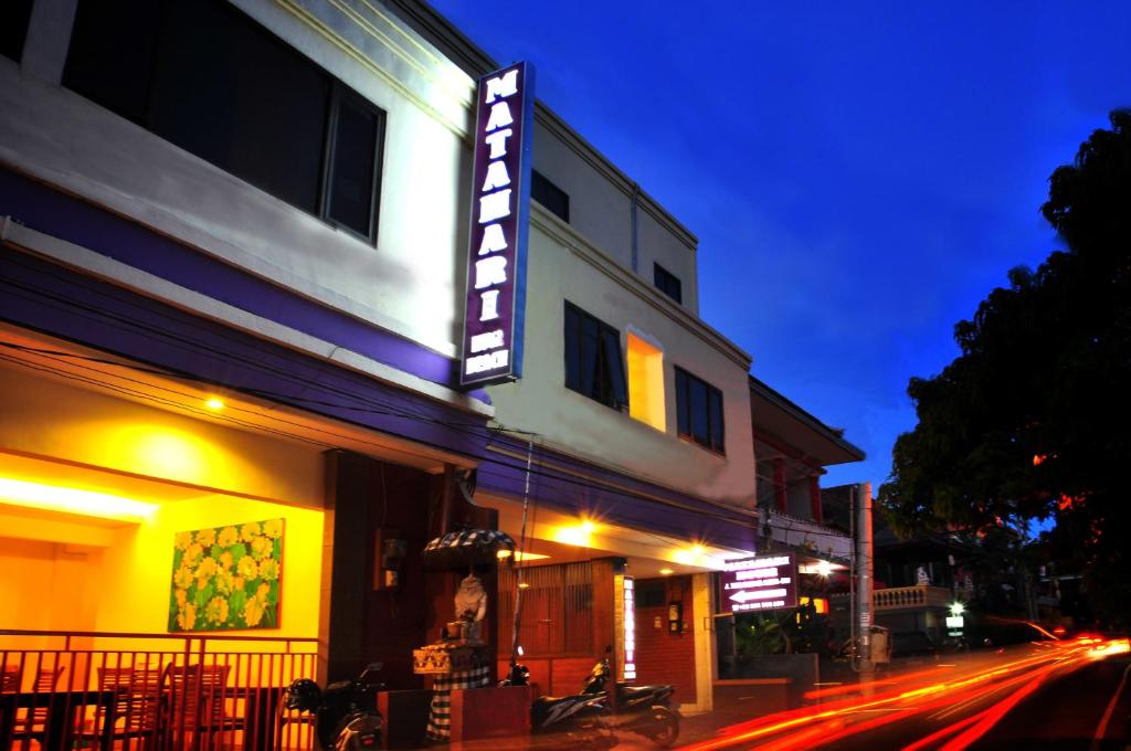 un bâtiment avec un panneau sur le côté d'une rue dans l'établissement Guest House Matahari, à Kuta