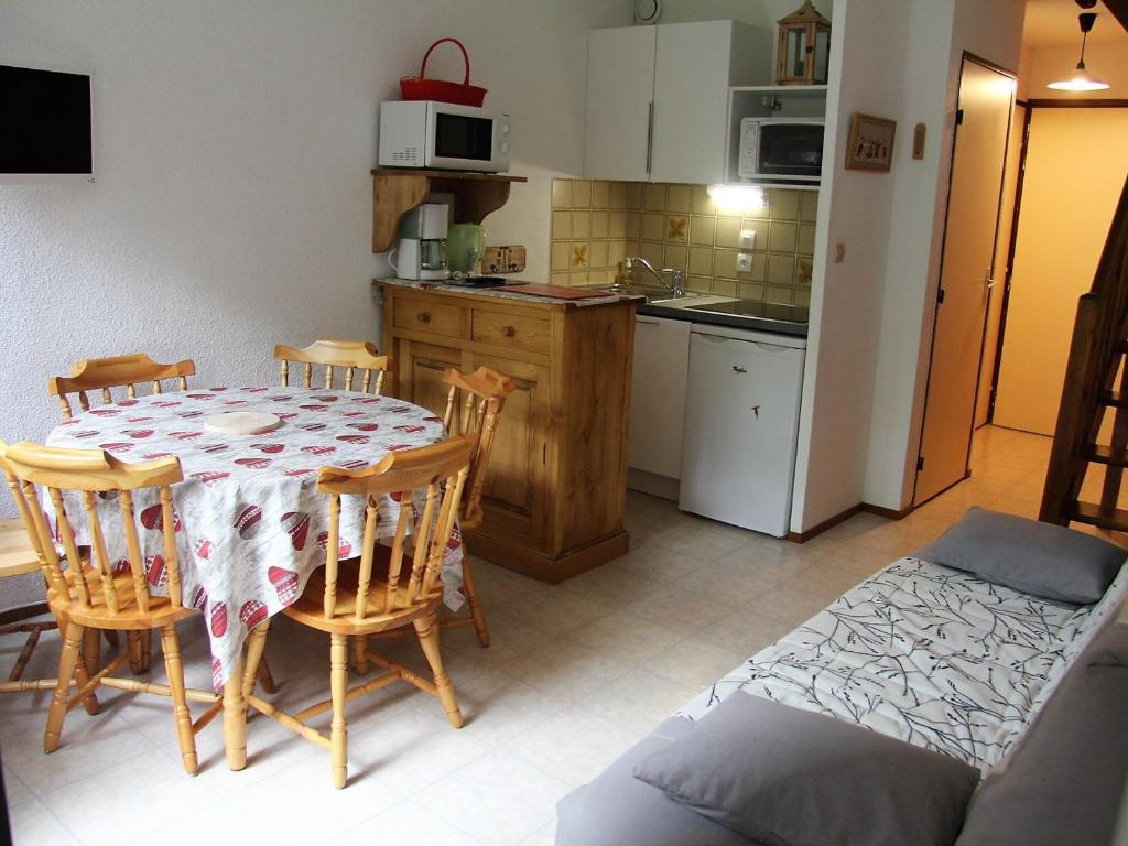 a kitchen with a table and chairs and a kitchen with a kitchen at Appartement La Clusaz, 3 pièces, 6 personnes - FR-1-459-147 in La Clusaz