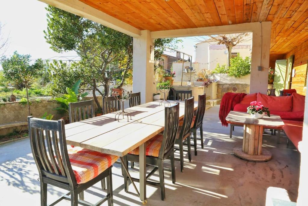 a wooden table and chairs on a patio at L'Oustaou Dorey in Saint-Cyr-sur-Mer