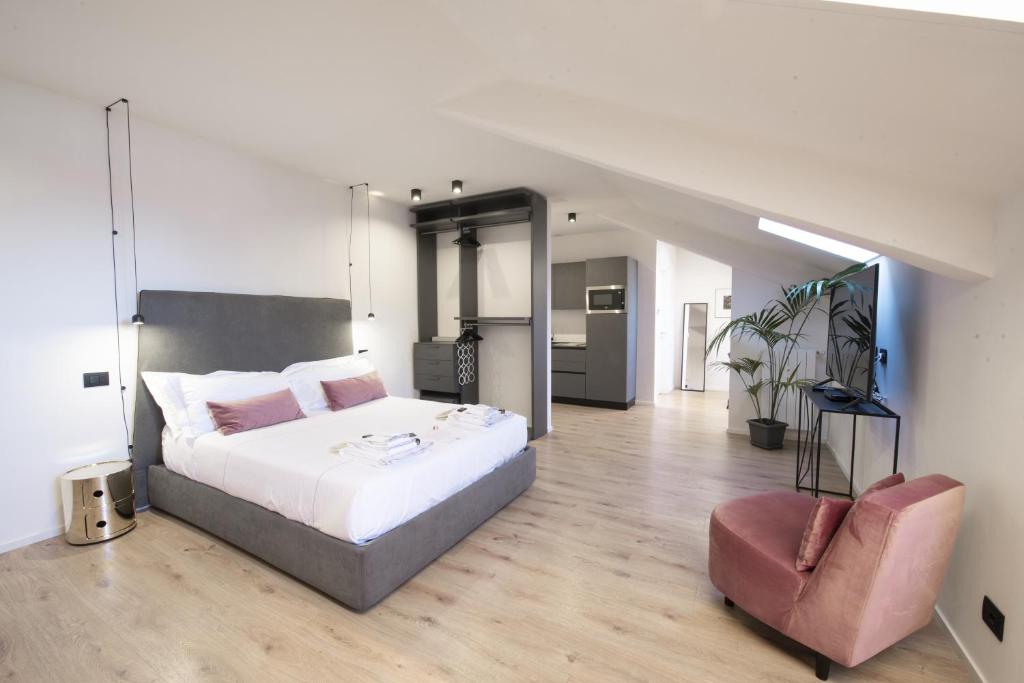 ein Schlafzimmer mit einem großen Bett und einem Stuhl in der Unterkunft San Carlo Suite Torino in Turin