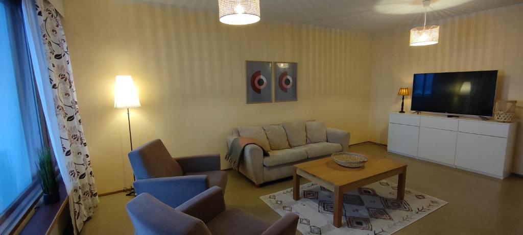 ein Wohnzimmer mit einem Sofa und einem TV in der Unterkunft Villa Astrid in Pietarsaari