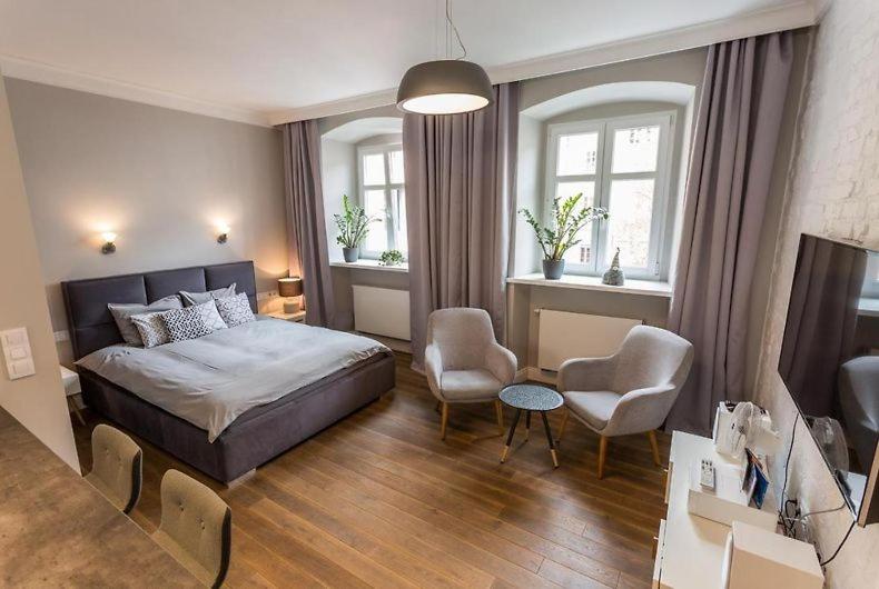 a bedroom with a bed and a living room at Muzyczna Oaza Przy Rynku in Wrocław