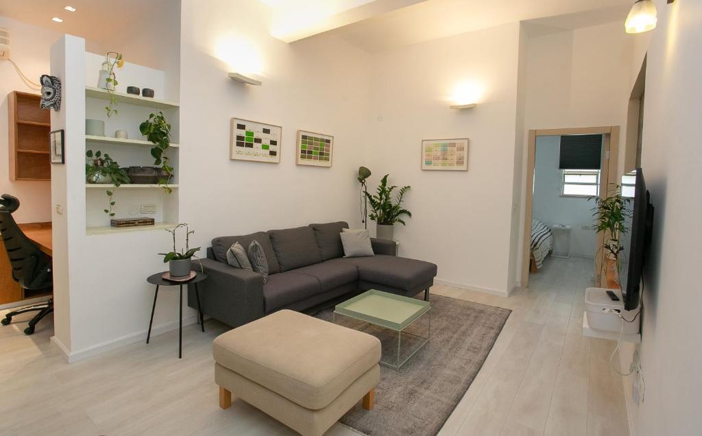 a living room with a couch and a table at 9 Sderot Chen - By Beach Apartments TLV in Tel Aviv