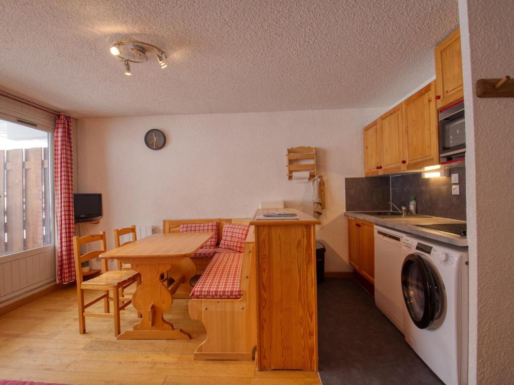 a kitchen with a wooden table and a table and a washing machine at Appartement Morillon 1100, 2 pièces, 6 personnes - FR-1-642-79 in Morillon