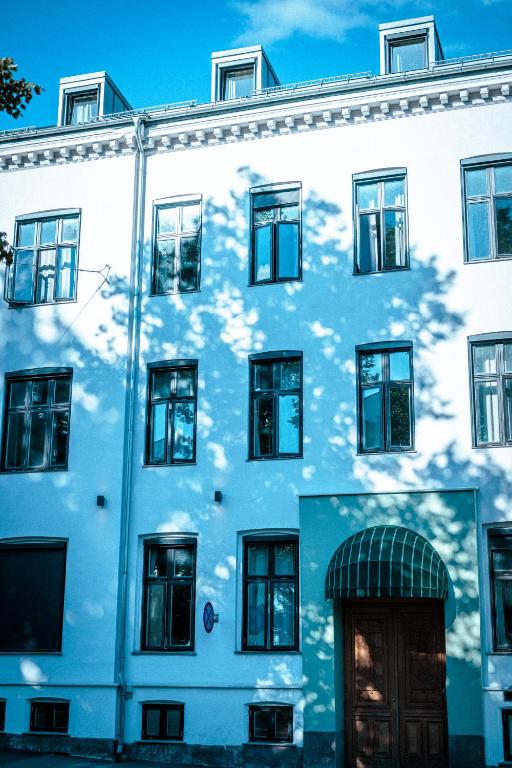 a white building with a shadow of a tree on it at Hotel Filip in Oslo