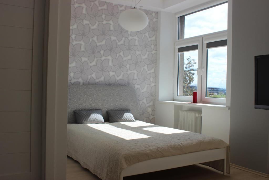 um quarto branco com uma cama e uma janela em Kaunas Center Apartments - K. Mindaugo g. em Kaunas