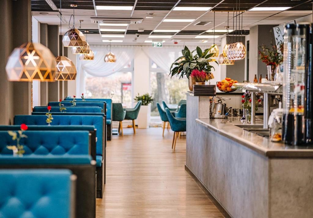 restauracja z niebieskimi krzesłami i barem w obiekcie Hotel Stronie w Stroniu Śląskim