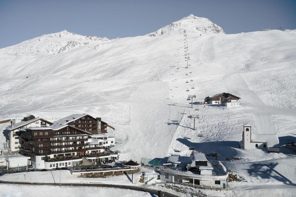 a resort in the snow with a mountain in the background at TOP Hotel Hochgurgl in Hochgurgl