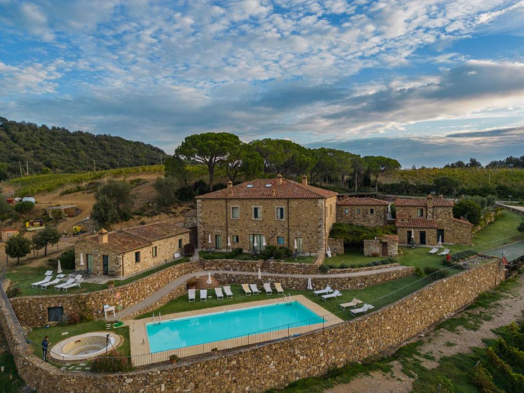 ein Grundstück mit einem Pool und einer Steinmauer in der Unterkunft Le 7 Camicie in Castelnuovo dellʼAbate