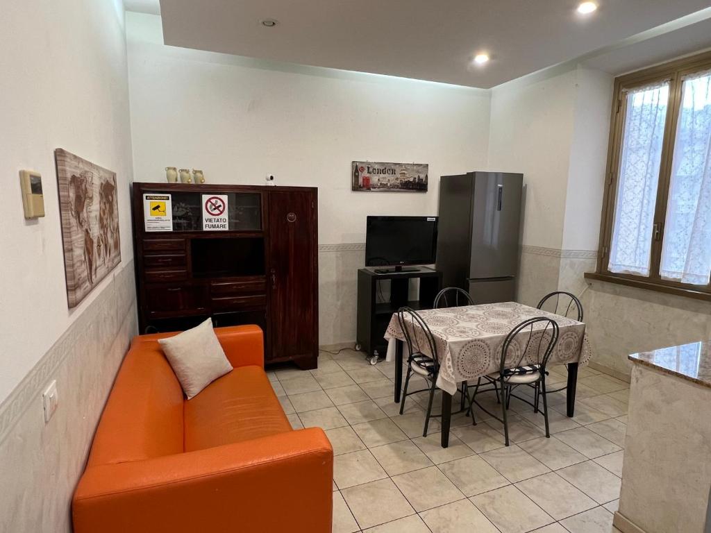 ein Wohnzimmer mit einem orangenen Sofa und einem Tisch in der Unterkunft Be Your Home - Casa Vacanze Il Conservatorio in Civitavecchia
