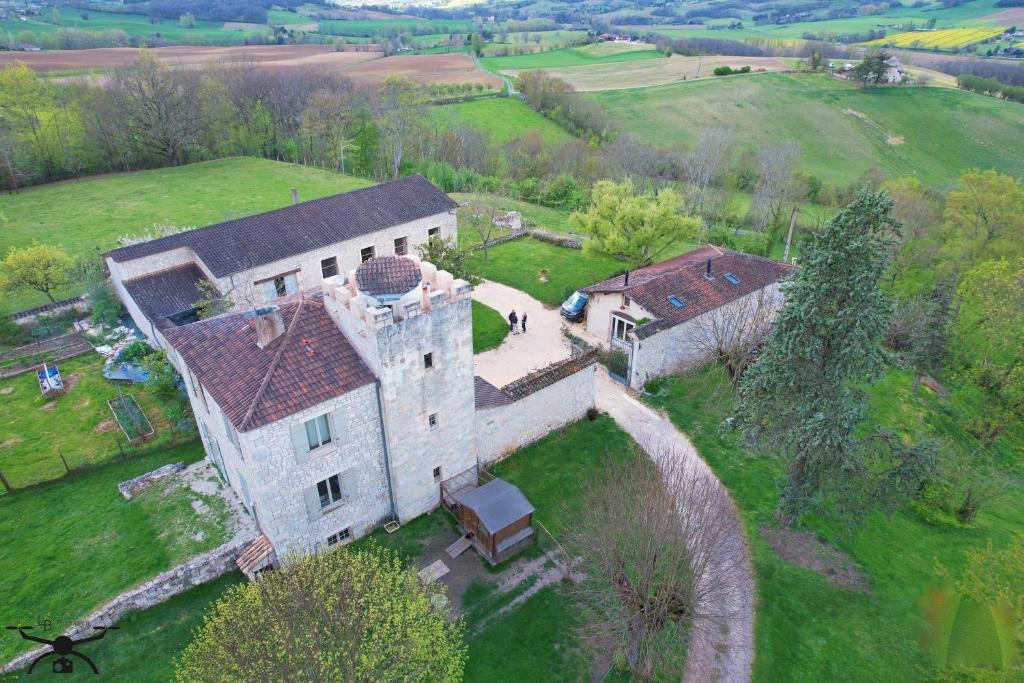 une vue aérienne sur un vieux bâtiment dans un champ dans l'établissement Le Manoir De Bonal, à Penne-dʼAgenais