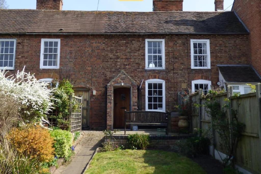 a brick house with a gate and a fence at Charming Grade 2 Listed cottage, Upton-upon-Severn in Upton upon Severn