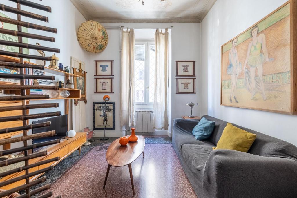 ein Wohnzimmer mit einem Sofa und einem Tisch in der Unterkunft Roma Retro Apartment - St. Peter Vatican in Rom