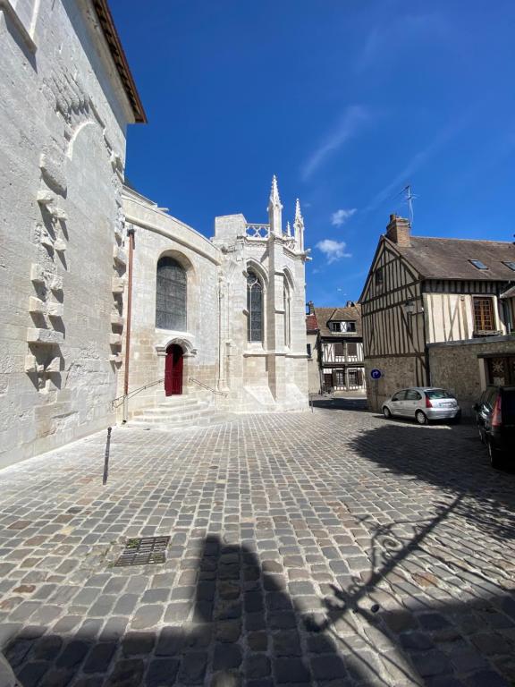 a church with a cobblestone street in front of a building at Appt cosy coeur historique+park, 5mn gare Vernon in Vernon
