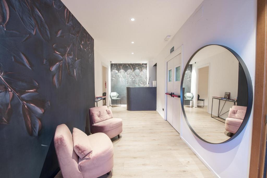 corridoio con sedie rosa e specchio di San Carlo Suite Torino a Torino