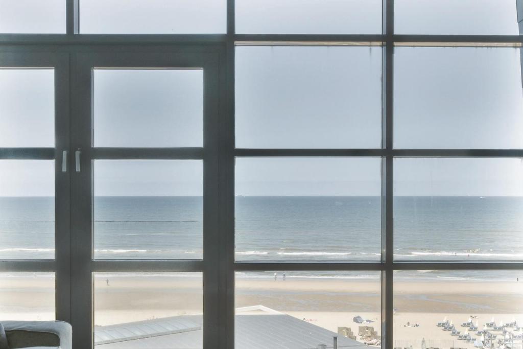 uma vista para o oceano a partir de uma janela em Appartement met zeezicht in Bloemendaal em Bloemendaal