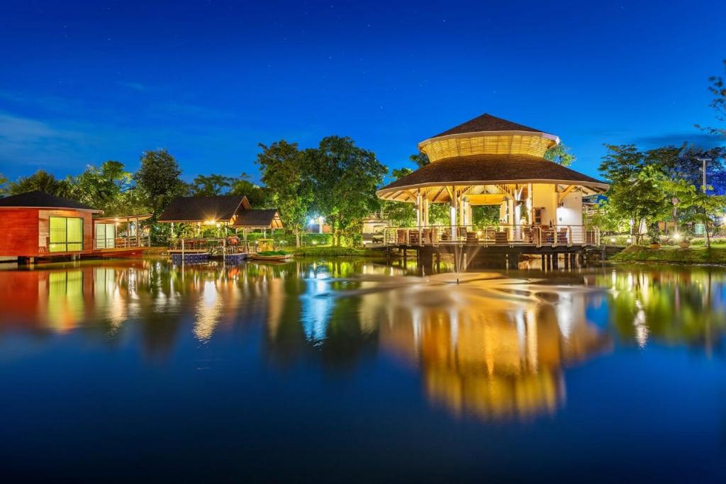 um gazebo ao lado da água à noite em boathouse boutique riverside em Talat Amphoe Nakhon Chai Si