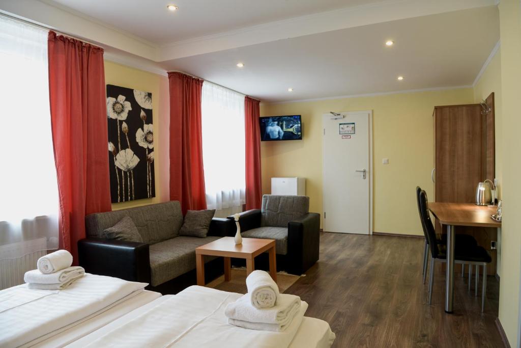 a hotel room with two beds and a living room at Hotel Heisede in Sarstedt