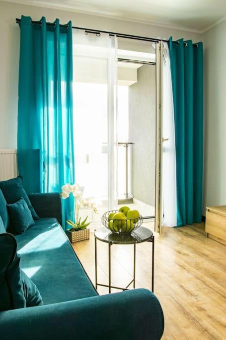 a living room with a blue couch and a table with fruit on it at Apartament Nowa Grunwaldzka in Suwałki