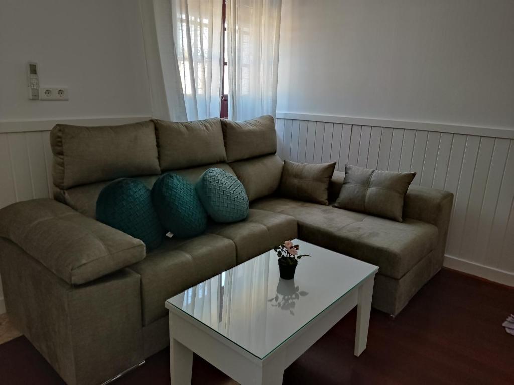 sala de estar con sofá y mesa de centro en Apartamentos BARBAS en Villanueva de los Castillejos