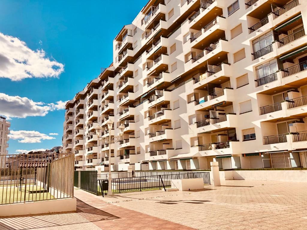 a large white apartment building on a street at Peñiscola playa in Peñíscola