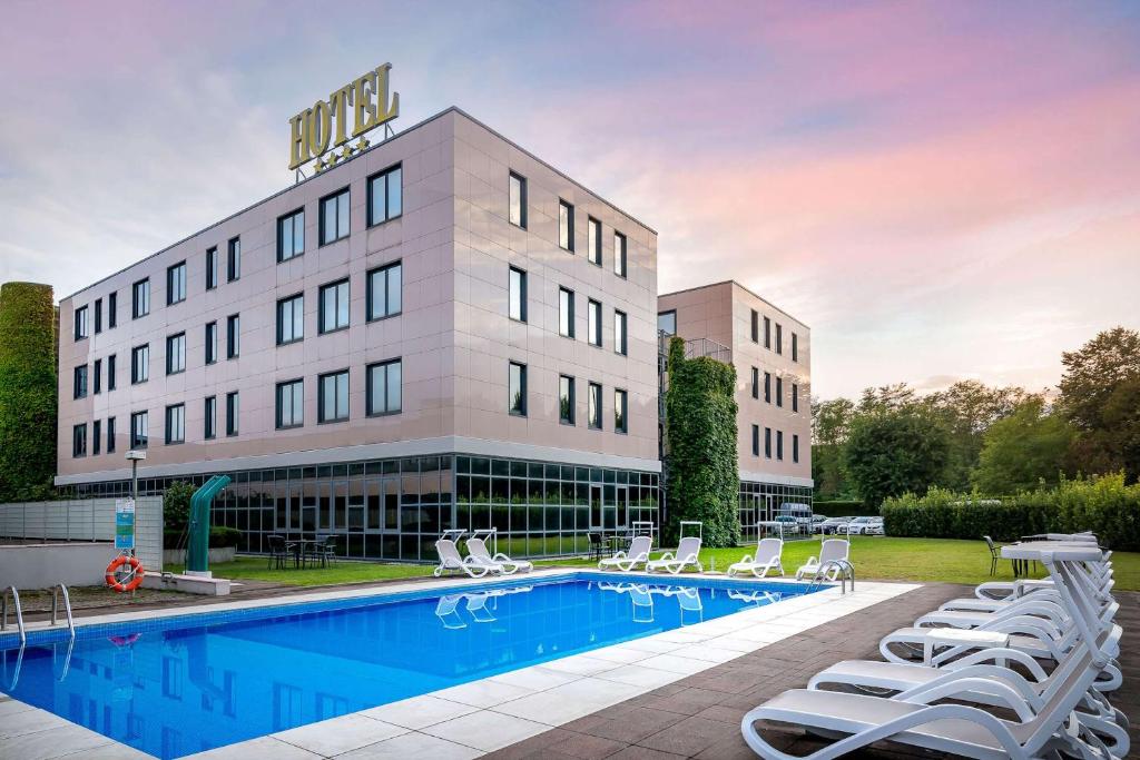 a hotel with a swimming pool in front of a building at Best Western Cavalieri Della Corona in Cardano al Campo