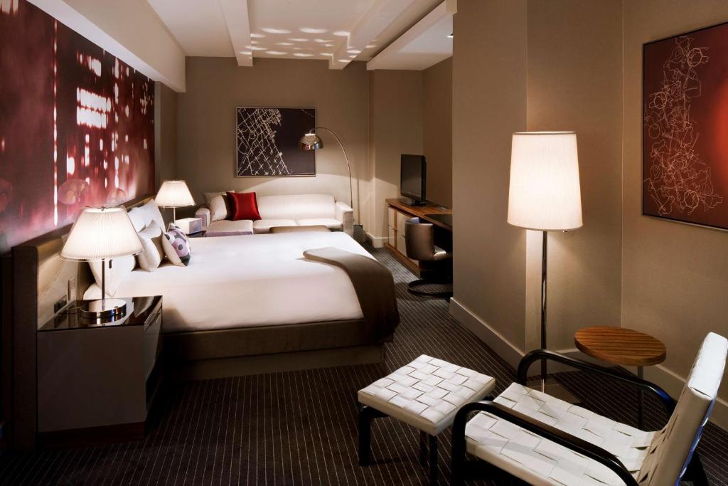 ニューヨークにあるHyatt Grand Central New Yorkの大きなベッドと椅子のあるホテルの部屋