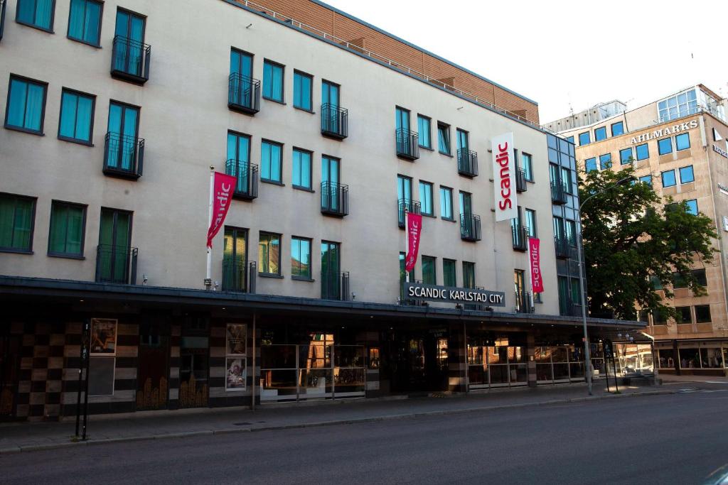 a large white building with blue windows on a street at Scandic Karlstad City in Karlstad