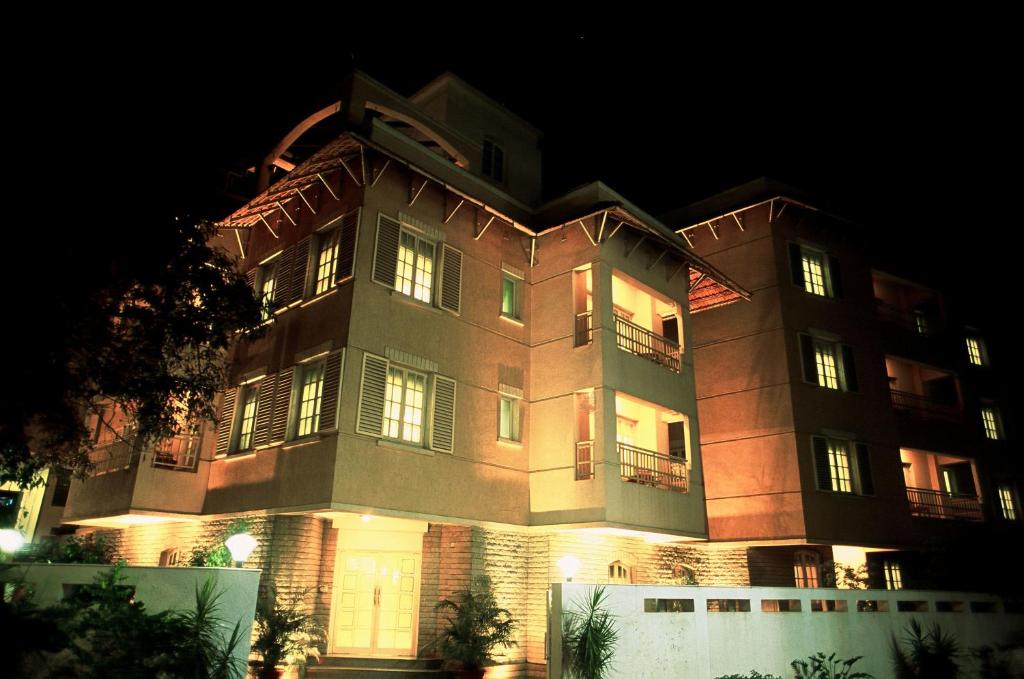 um grande edifício à noite com as luzes acesas em Tristar Serviced Apartments em Bangalore